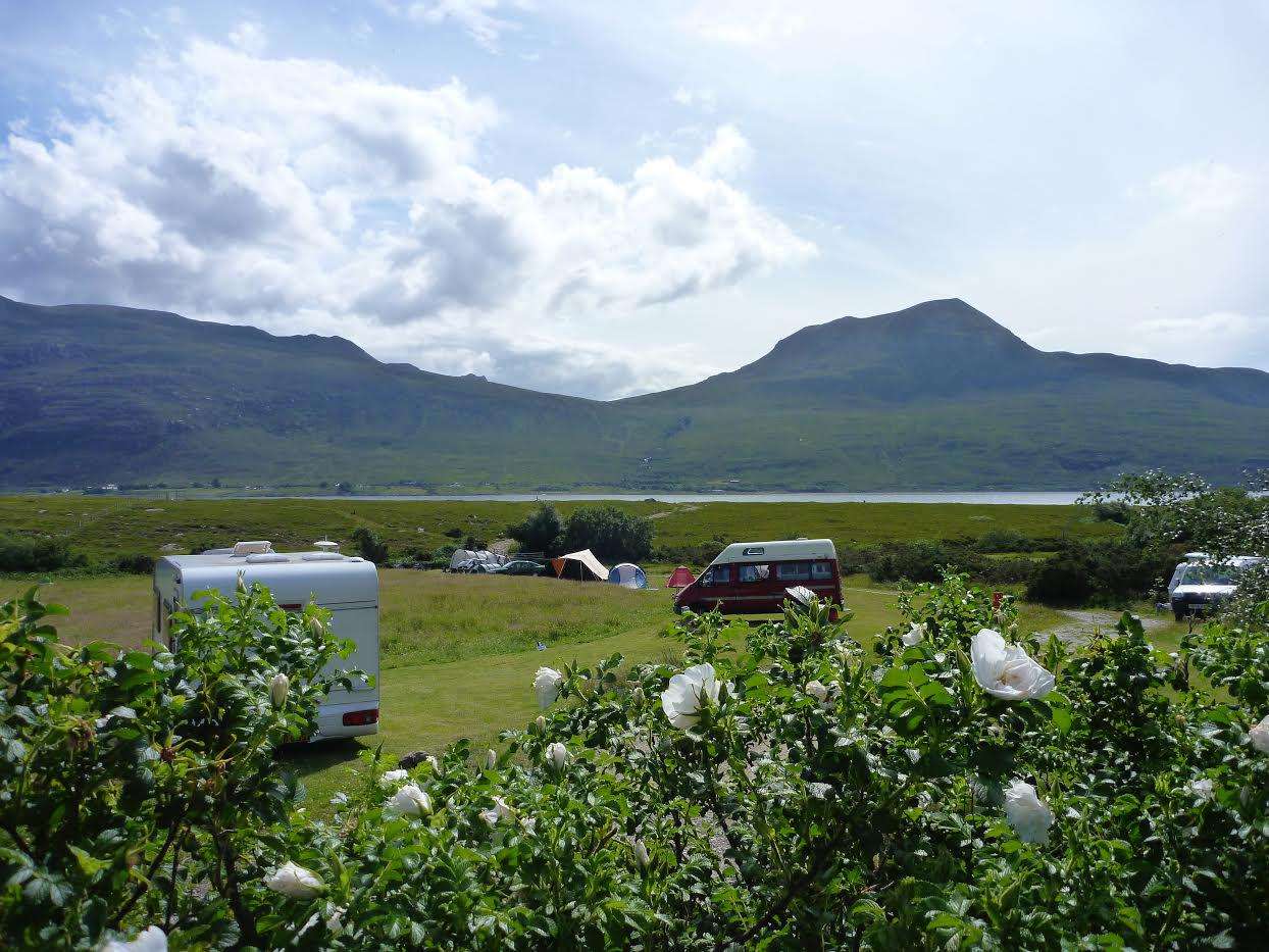A grass pitch with Electric Hookup at Badrallach. Bring a campervan to this lochside loaction in Scotland, plug in and switch off!