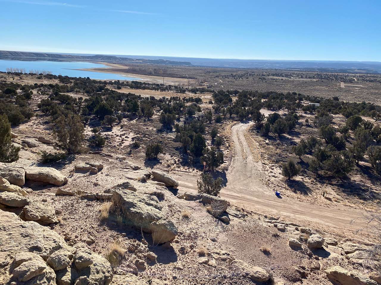 view of property, entrance road, and Lake from top of rock wall overlooking site.