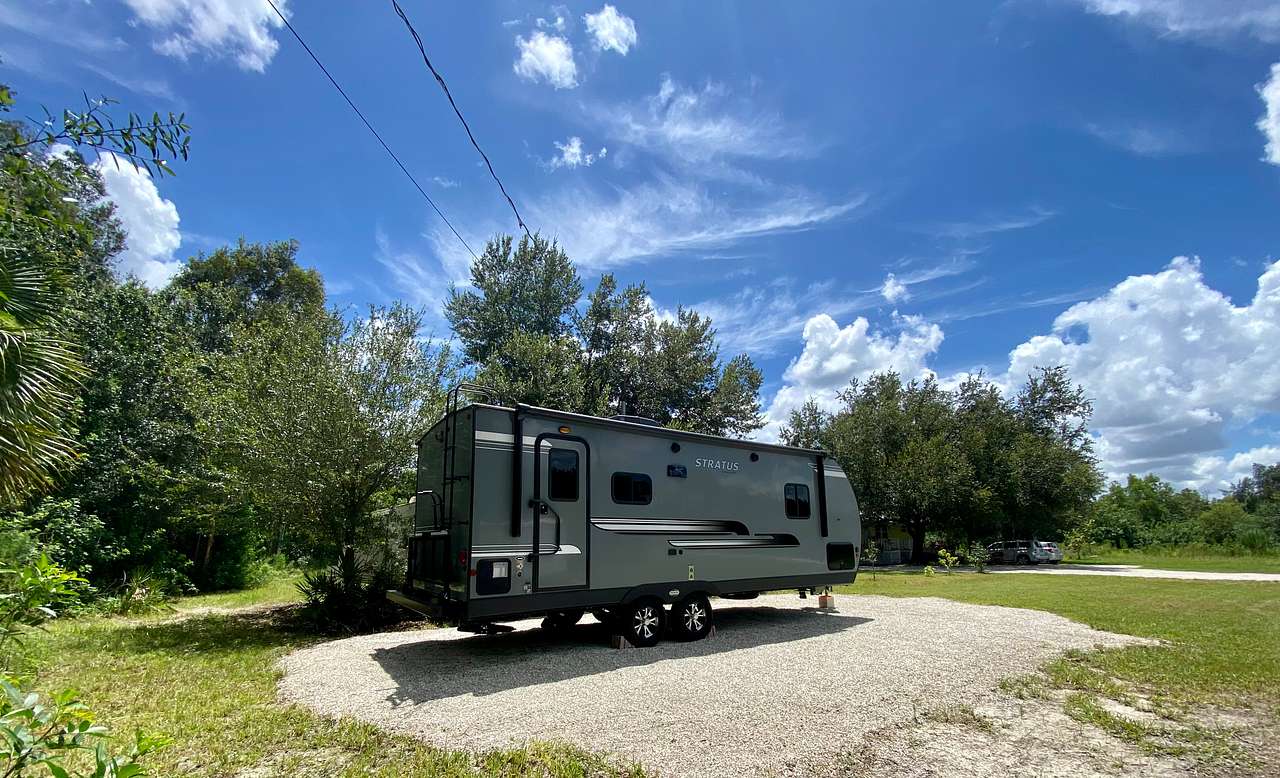 Cute travel trailer parked at RV Site #1 with Electric and Water Hookup. RV Site #1 has a small grassy area right behind it perfect for grilling.