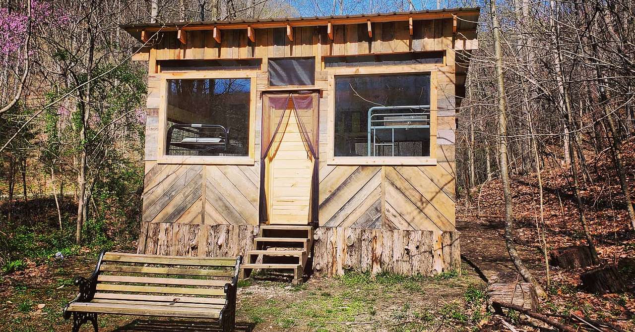 Simple, 1-room bunkhouse made with salvaged wood, doors, and windows.