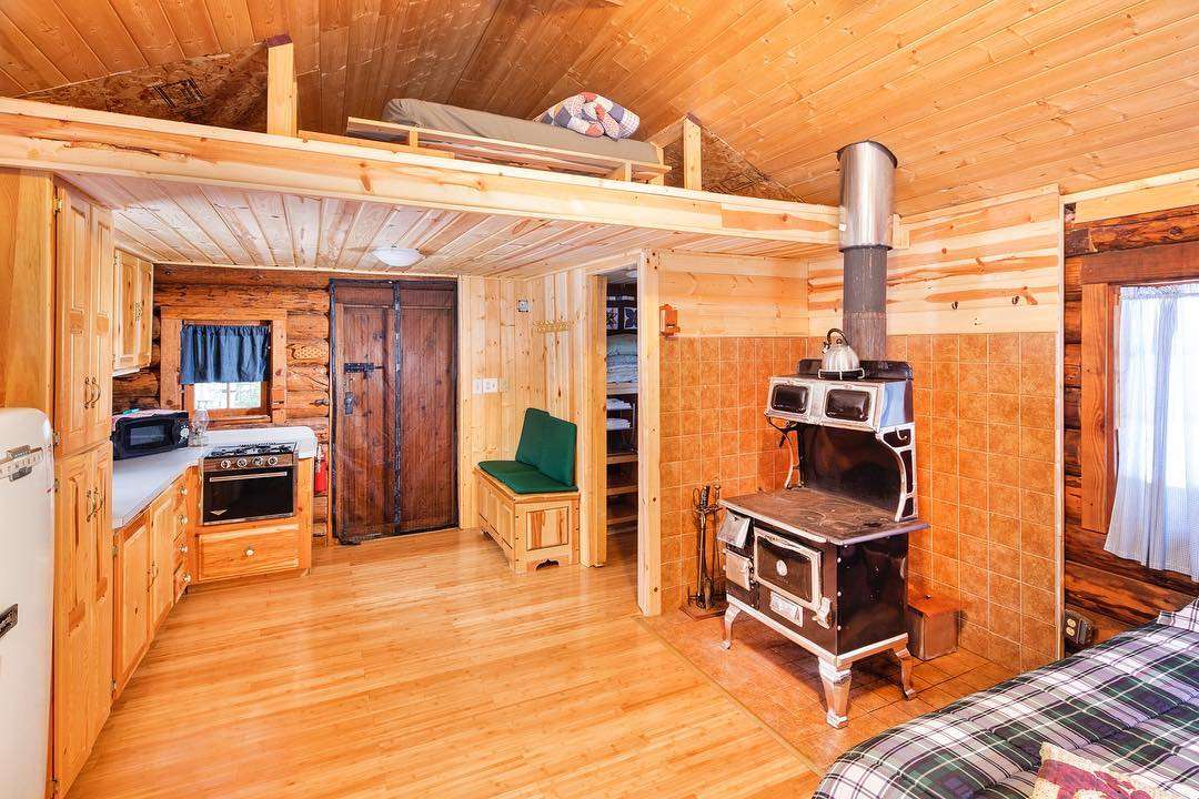 The cabin has a queen bed set up with a cot available. The low loft is accessible by a ladder (no rails, as shown) and has a queen bed set up. Max occupancy is 5 guests.