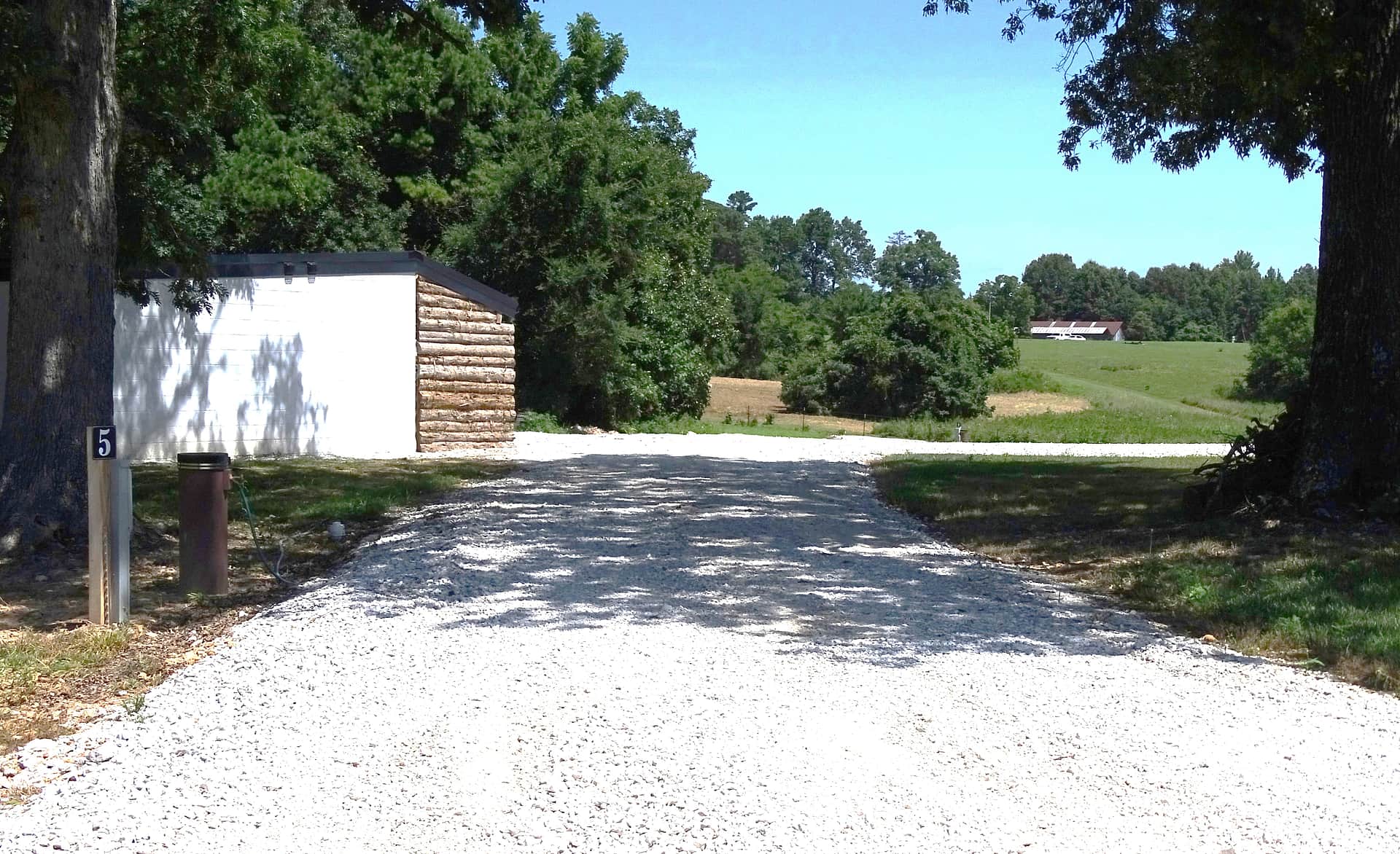 View of Site #5. It is a pull thru site, approximately 85' feet in length. 50/30/20 amp service is available. This site is the closest to the shower building, and is also well-shaded.