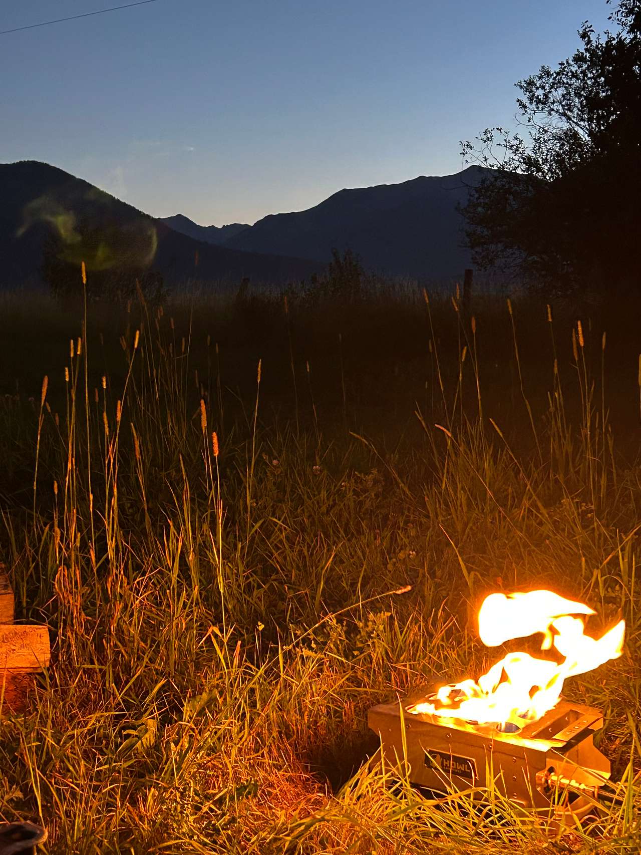 Howl propane fire pit backdropped by the silhouette of the Wallowas. 