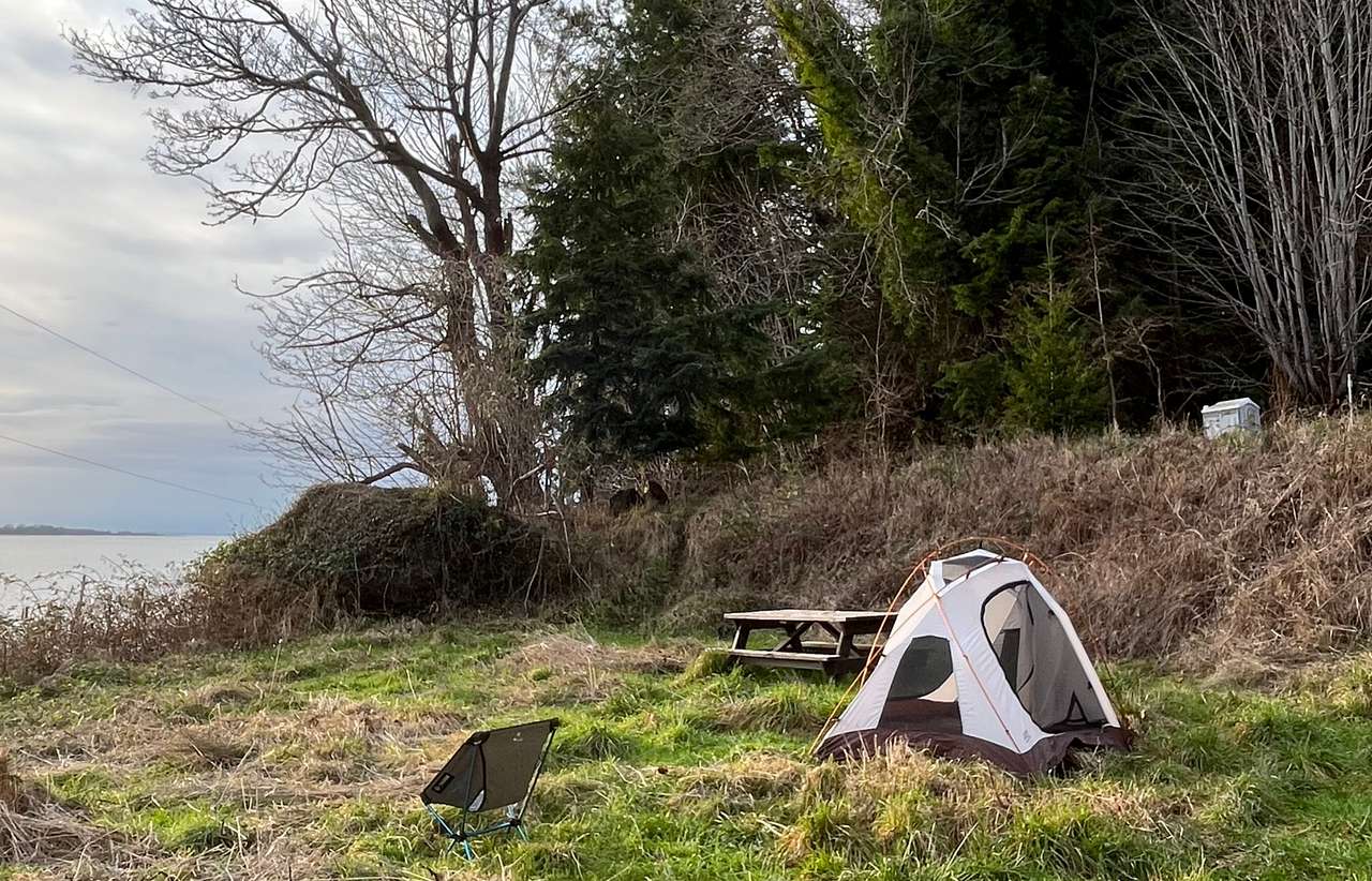 Looking west at Riverside Camp. The portable toilet can be seen in the upper right corner, a short walk away from the site. Parking for 3-4 vehicles is near the toilet; 2 cars are allowed near the tent site. 