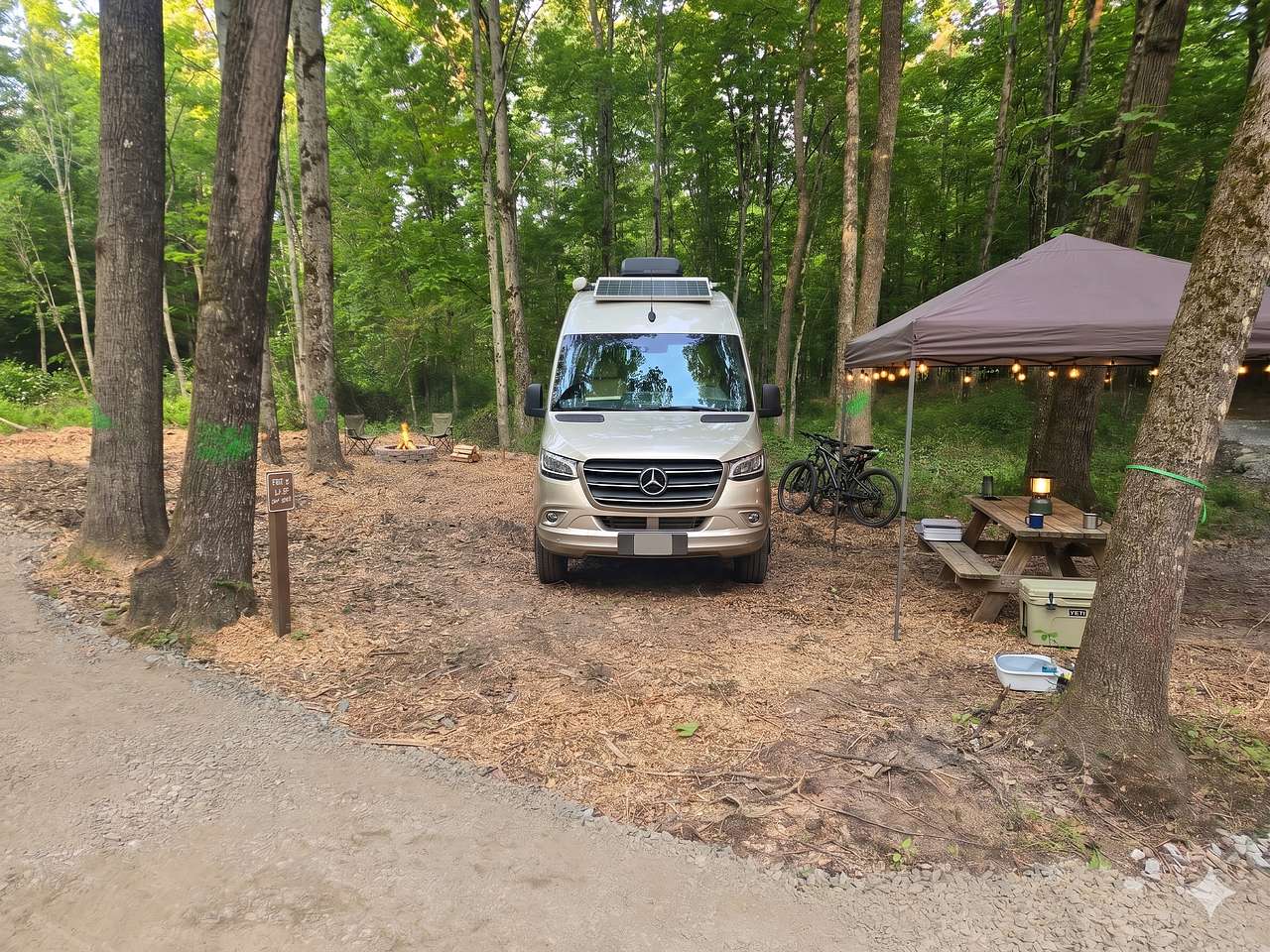 Mostly level pull-in site for a campervan or smaller RV. You can pull into the site as shown or park your vehicle alongside the site on the stone driveway. 