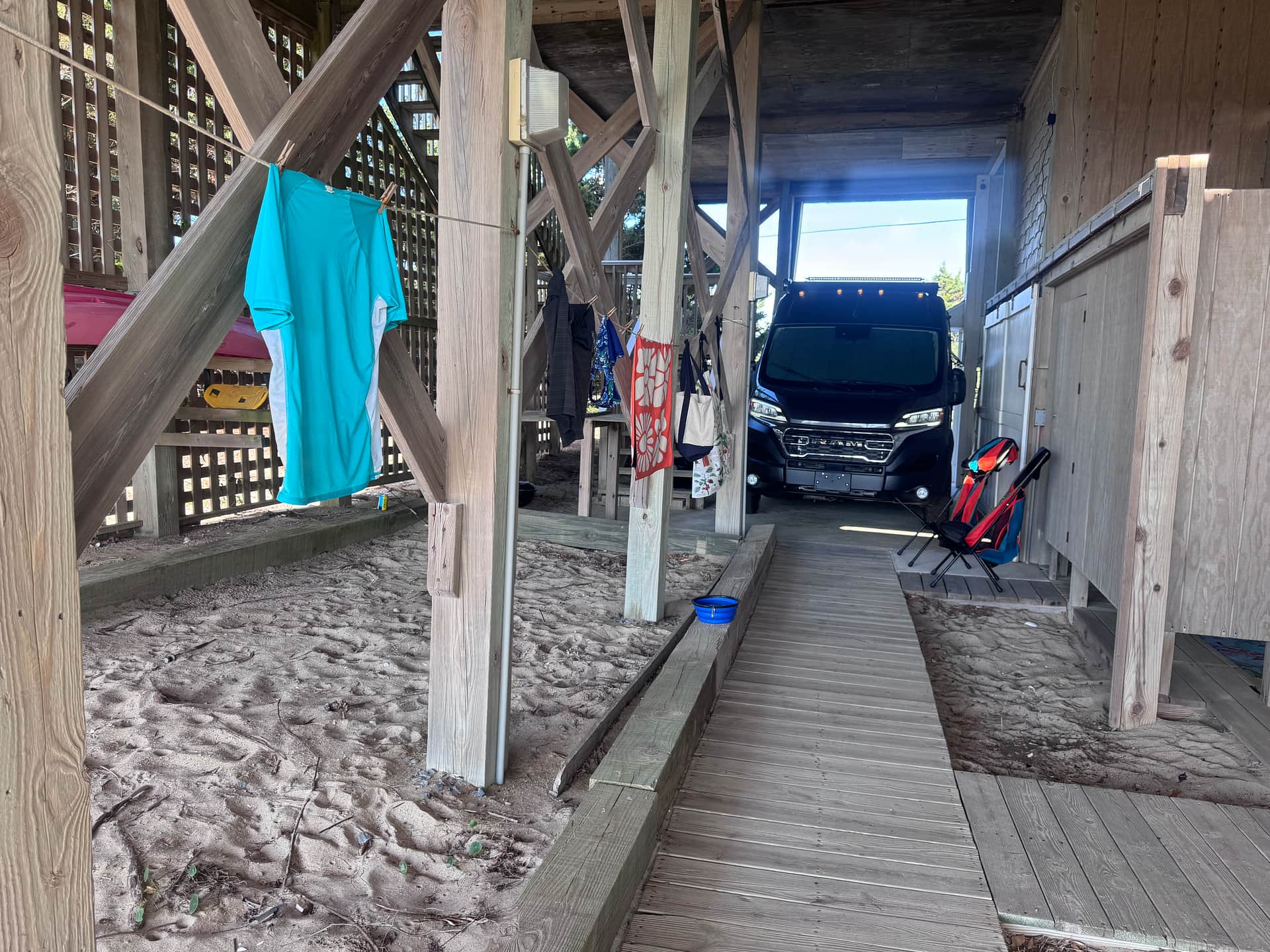 Our Promaster in the shade with access to the shower and the toilet.
