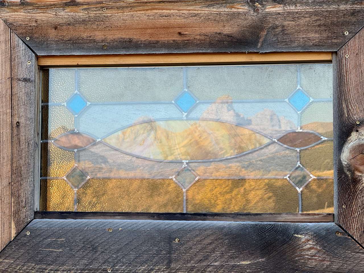 Teton reflection in the stained glass window of the barn!