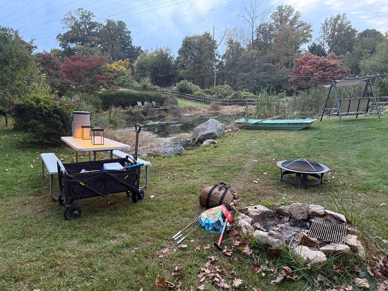 Fire pit, picnic table, row boat, and pond