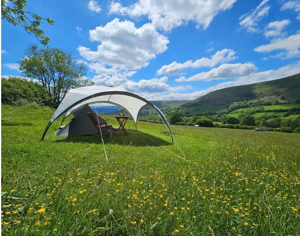 Tent pitches are 5m x 7m levelled grass pitches, chosen on arrival by guests. Access is on foot only and distance from carparks is between 30m and 250m up a gentle slope depending on choice. Wheenbarrows are provided to move kit. Views are stunning of the valley below :)