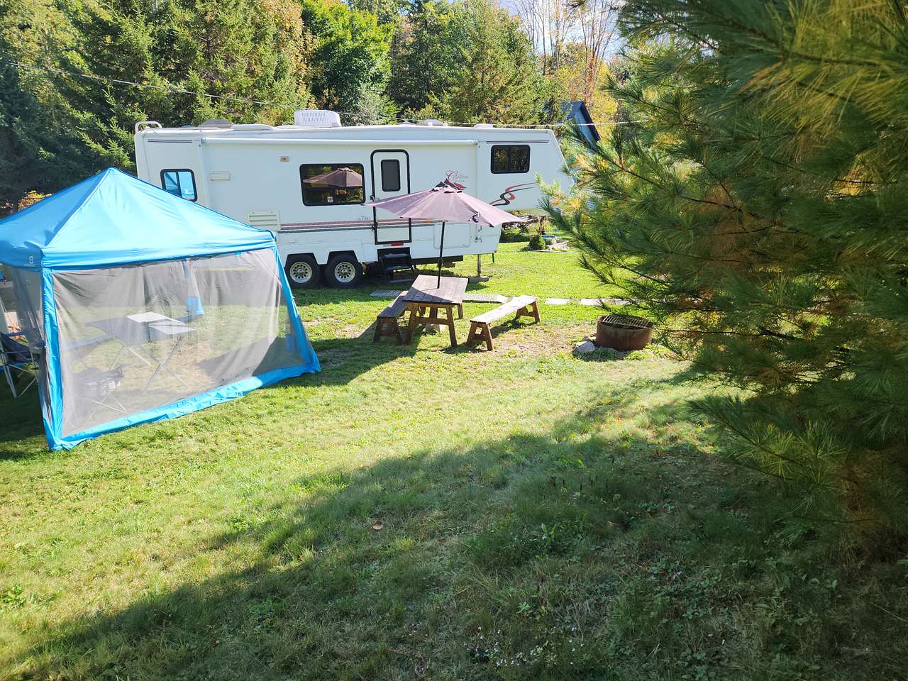 General layout showing the camper, picnic table and canopy.
