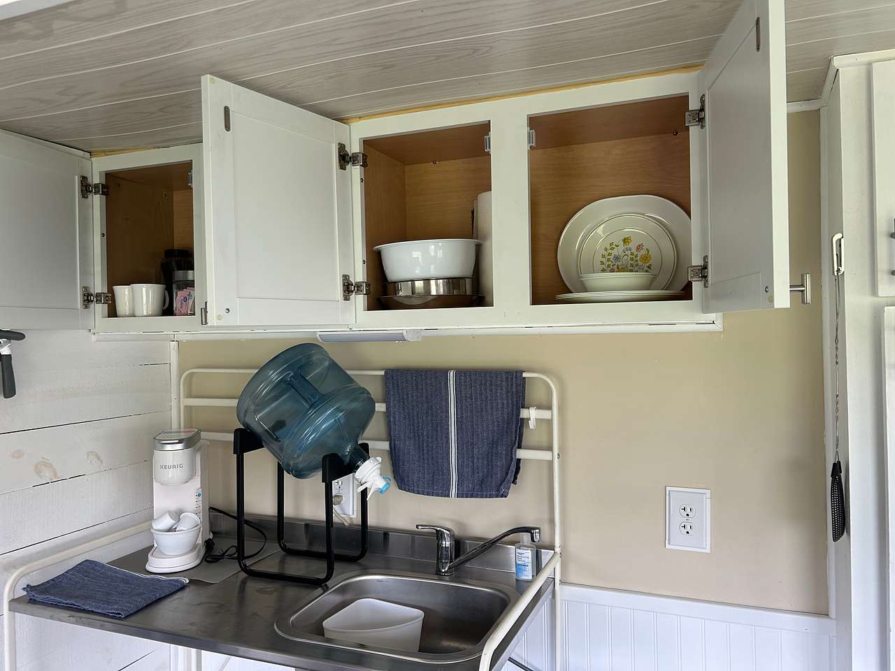In addition to disposable tableware, we include the use of regular plates, glassware, mugs, a few serving bowls, and cutlery. No cooking inside of the camper, there is a fire ring with a grate outside. Many guests bring in takeout food from the many local restaurants or utilize a delivery service. We do offer firewood, blueberry muffins and apple crisp in the extras section when booking. The seasonally available shower is cold water only. 