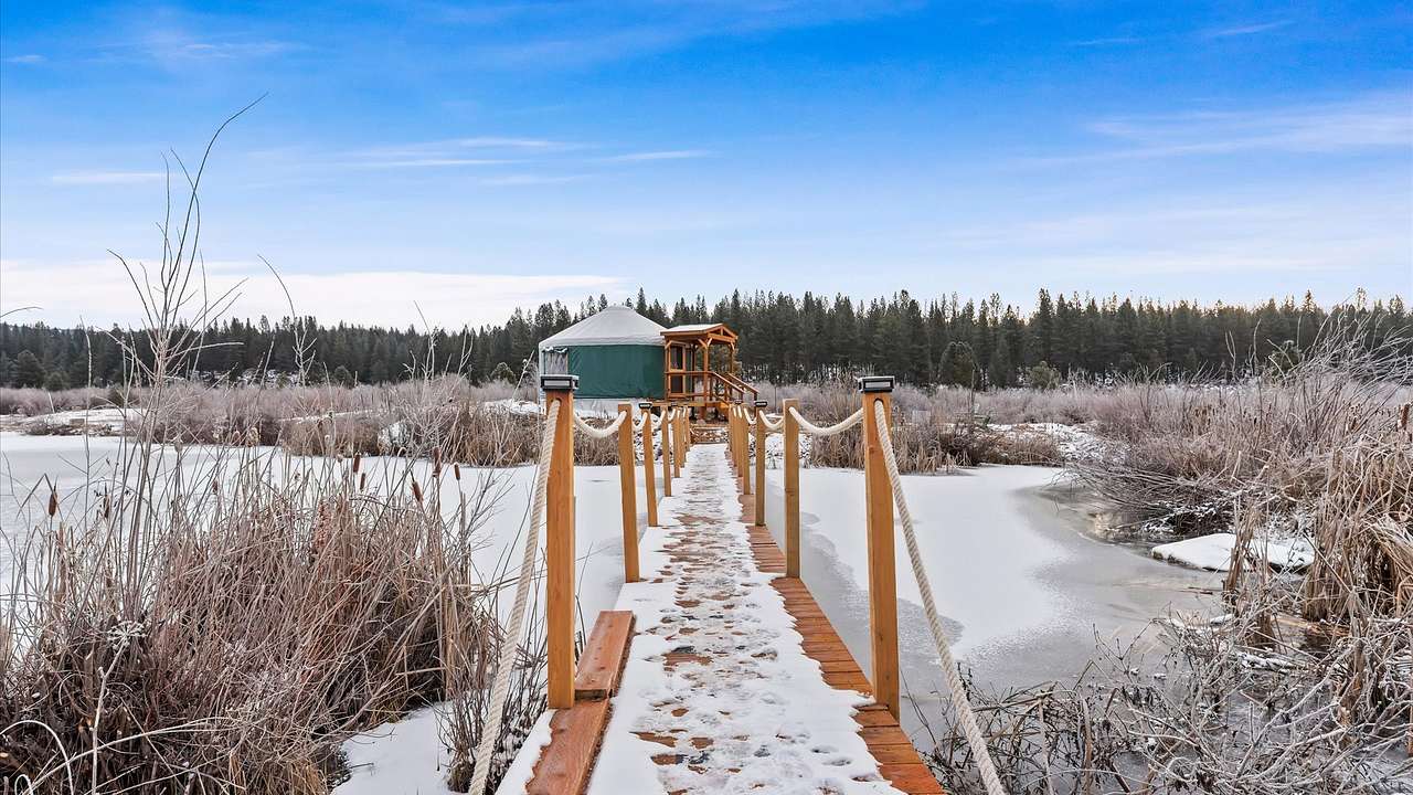 Gold Miner yurt winter view from footbridge across beaver pond.
