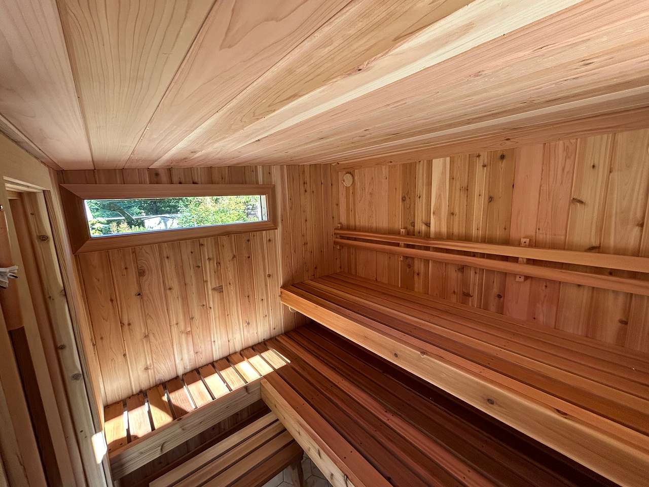 Olalla Sauna is large enough to seat eight people and has extra deep benches for a feet above the rocks sauna experience.