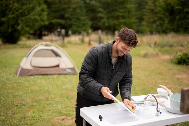 host-washing-dishes-at-campsite