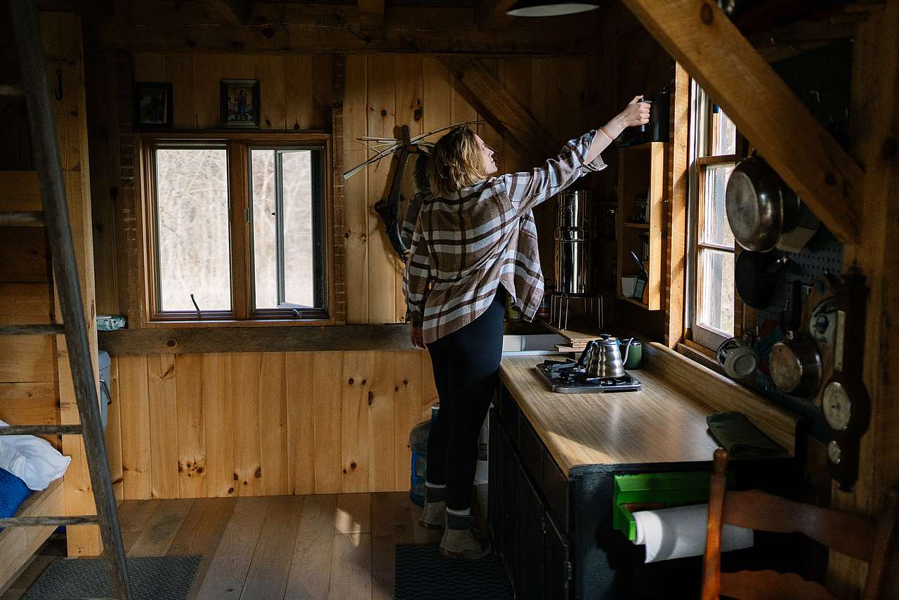 The kitchen has a propane stove, a berkey filter for drinking and hand washing, and other essentials like pots, pans, bowls, and plates