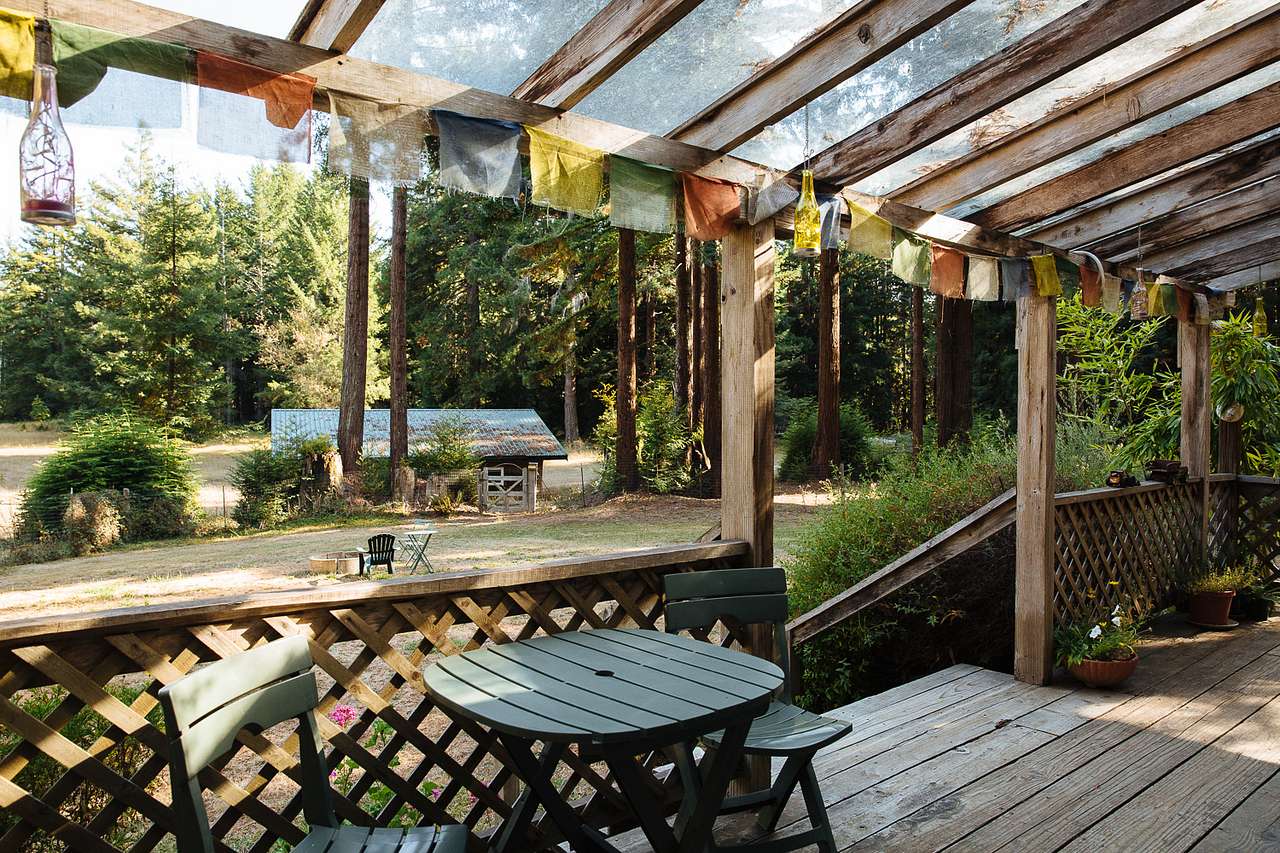Cute cafe table on porch, and stairs leading to front yard area. 