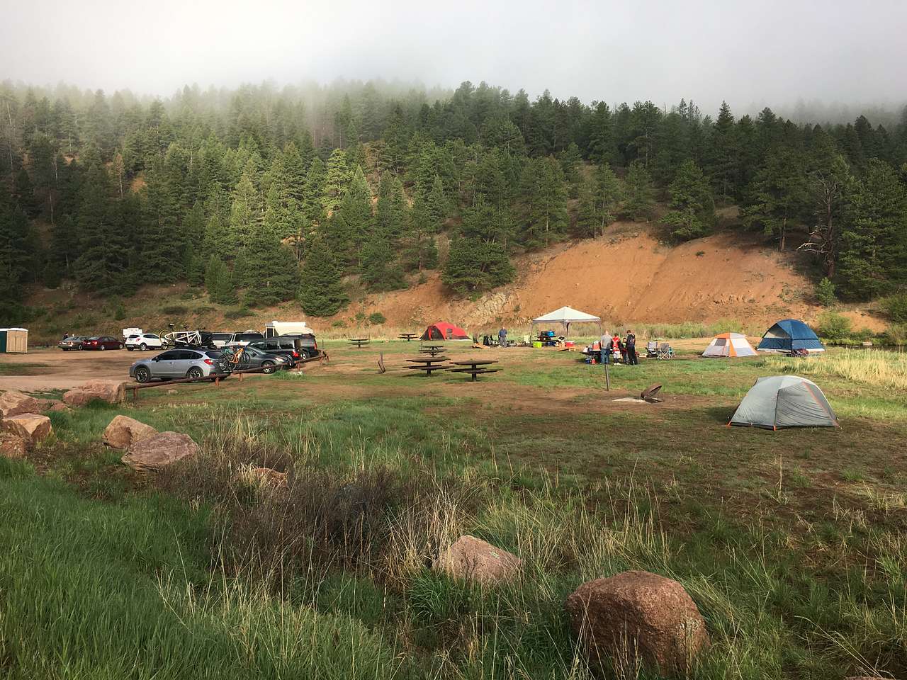 This is basically the whole campground. The river runs behind the sites to the right and the road is to the left .