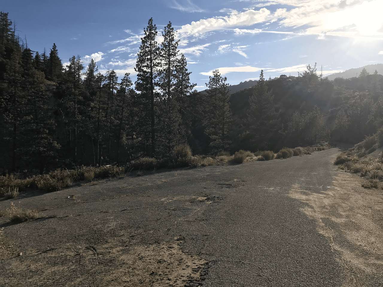 Standing in the "parking lot". Road to drive in is on the right, gated road down to the campsite is to the left.