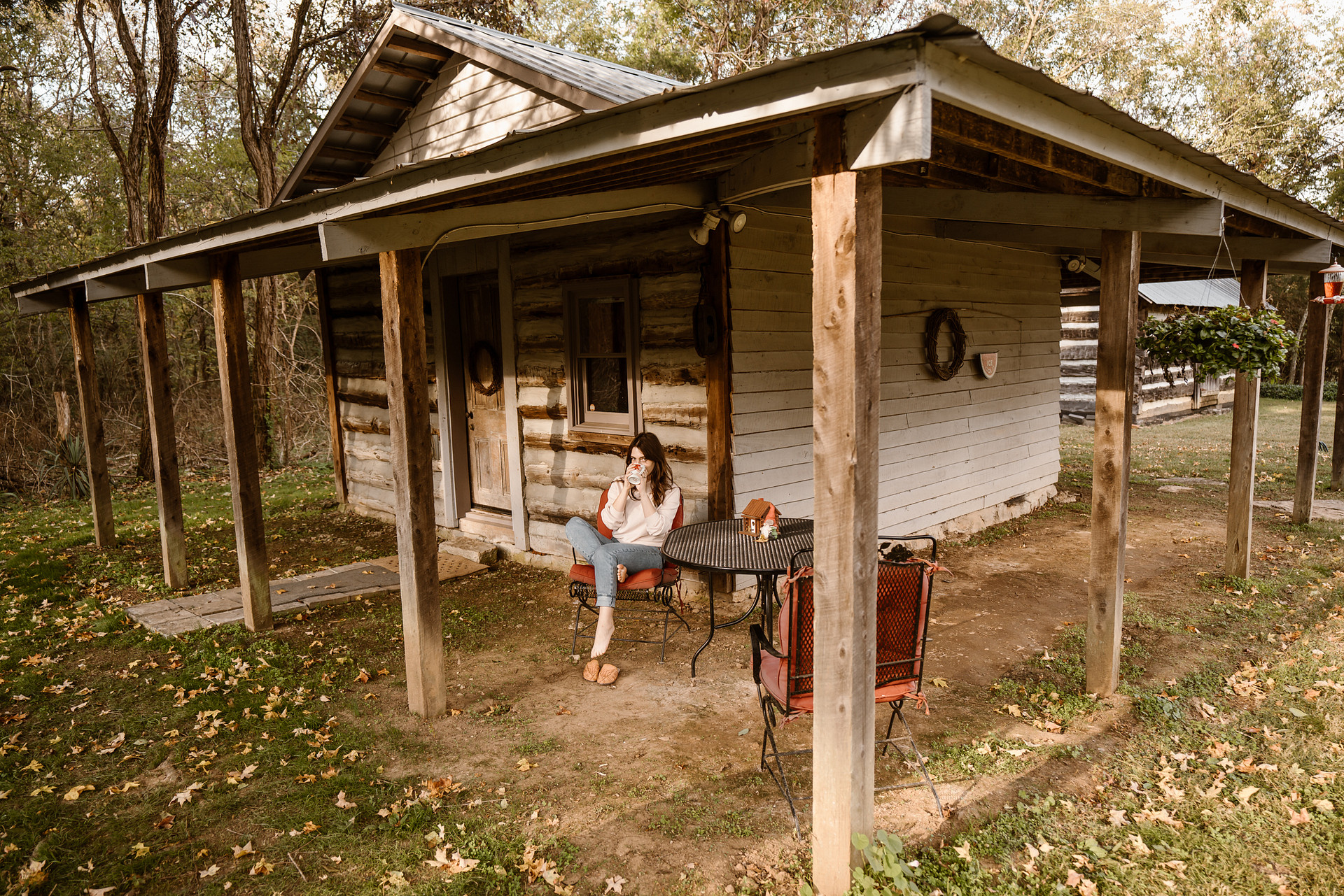There’s a patio table and chairs set up outside of the cabin.
