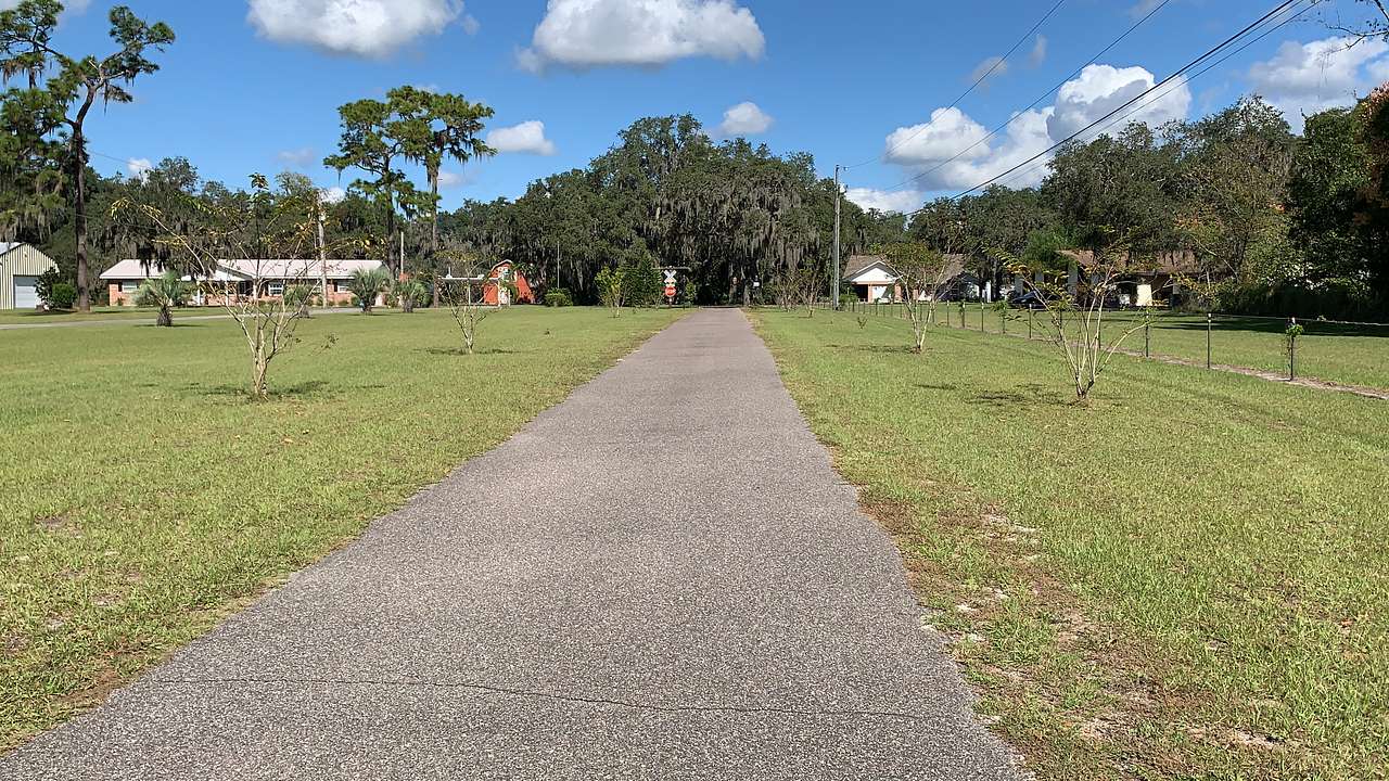 Stop sign by trees will guide in from paved driveway.