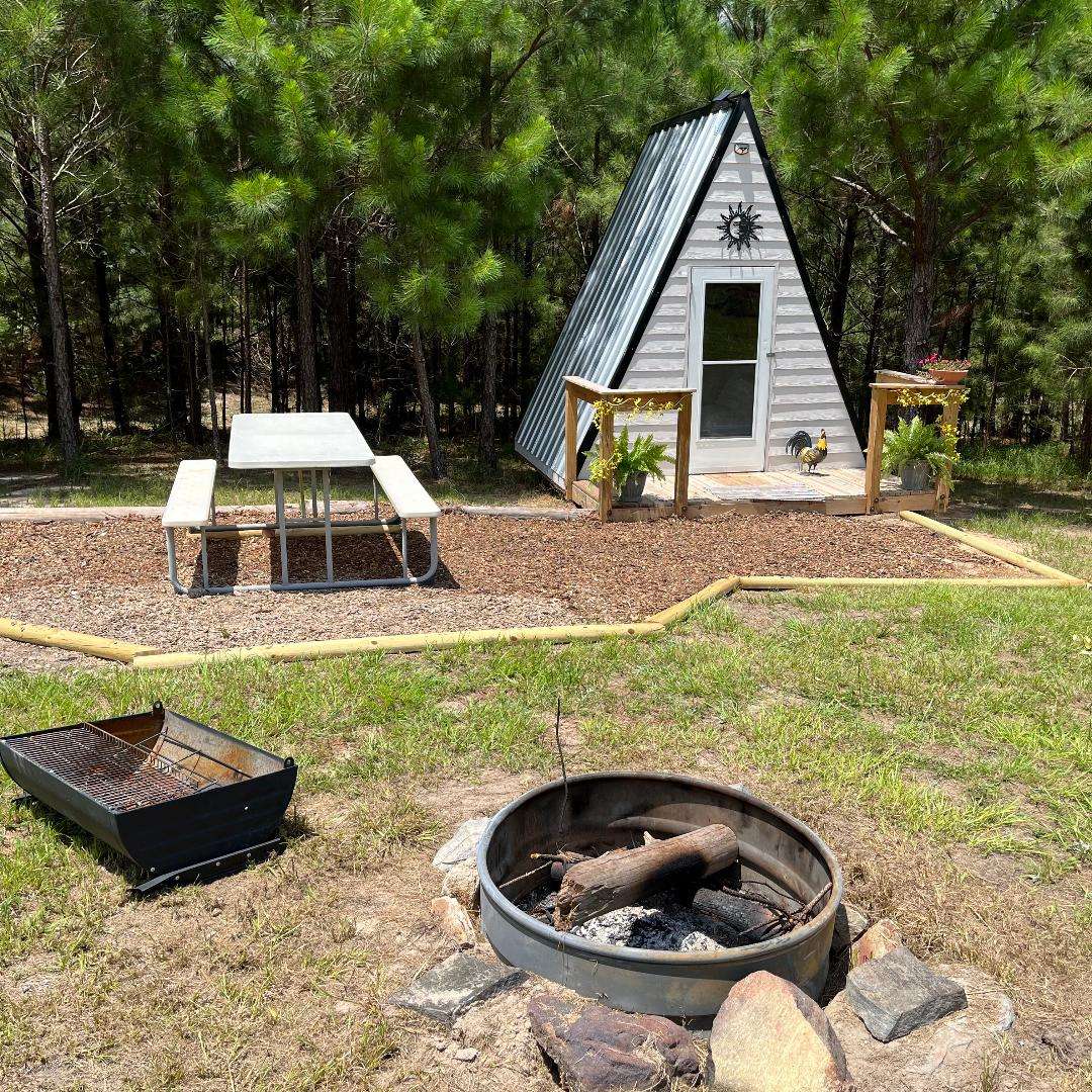 This is our small A-frame with a queen size bed and air conditioned. It also comes with a fire pit and camp grill. Perfectly cozy for 2 people. 