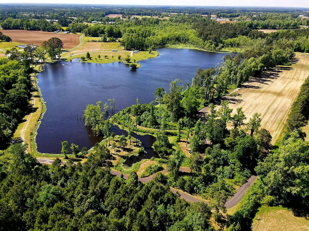 Drone shot overlooking tent sites and farmed fields. 
