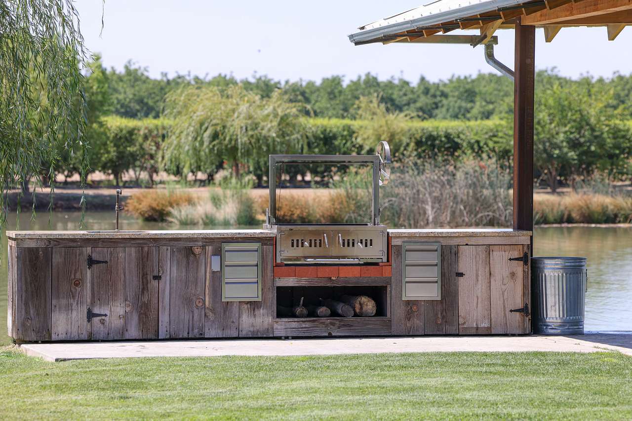 Kitchenette area with sink, counter space, and Santa Maria grill. Concrete area with covered gazebo.