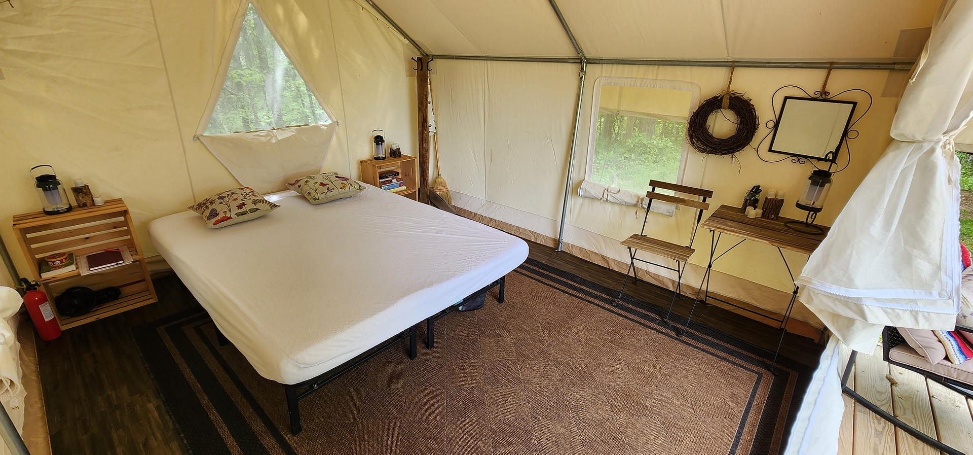 Inside of platform tent has a queen size bed, table & chairs, side tables with games, and a coat rack. In colder months we also have a propane heater.