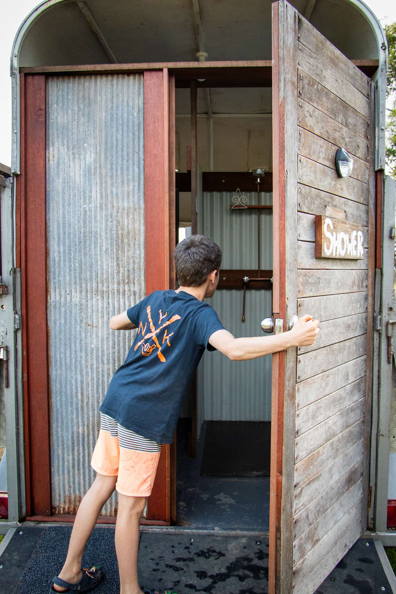 Quirky hot water shower in a converted horse float.