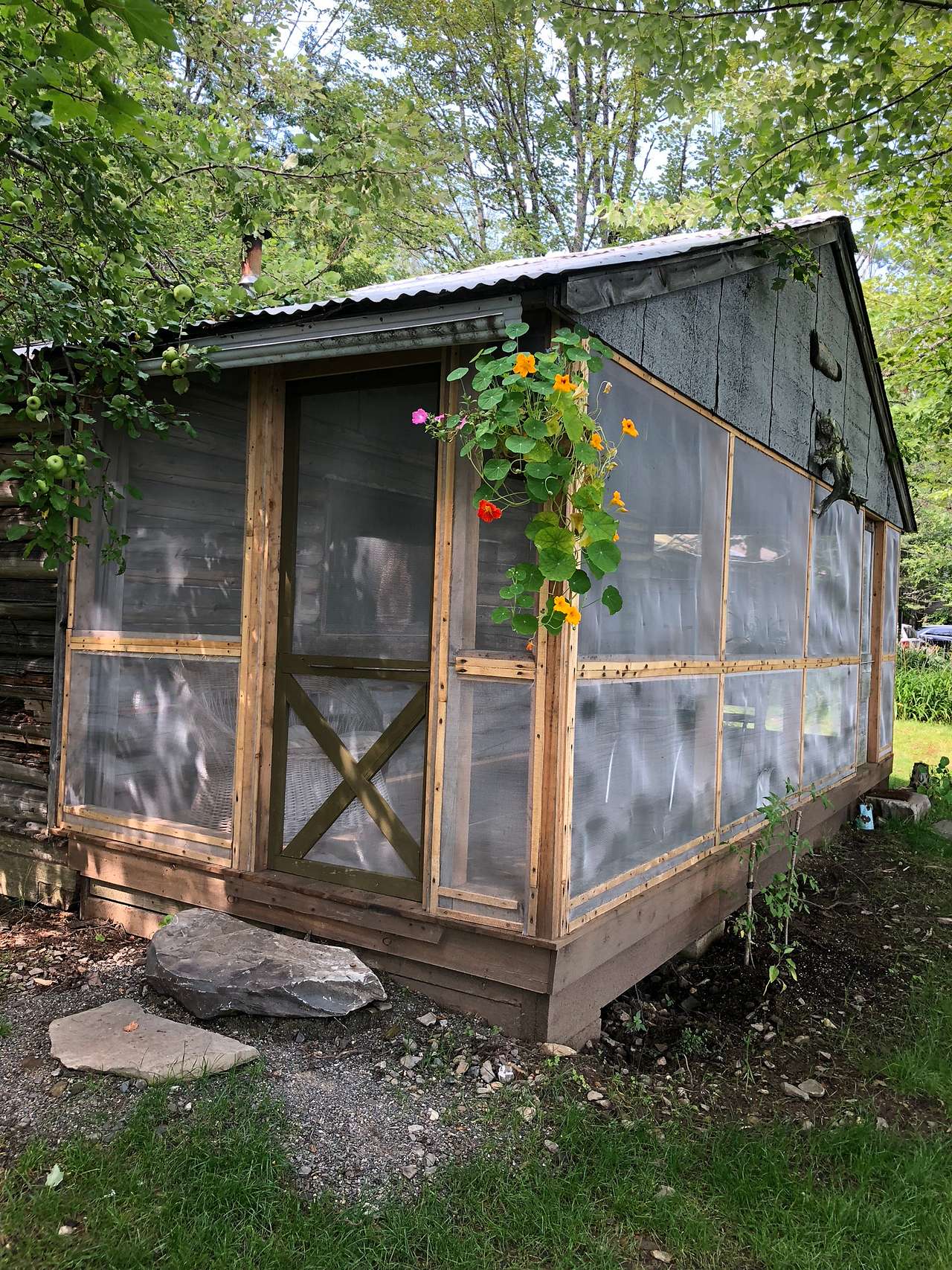The front porch of Trapper Bill's Cabin is screened and has a dinning table and chairs.
