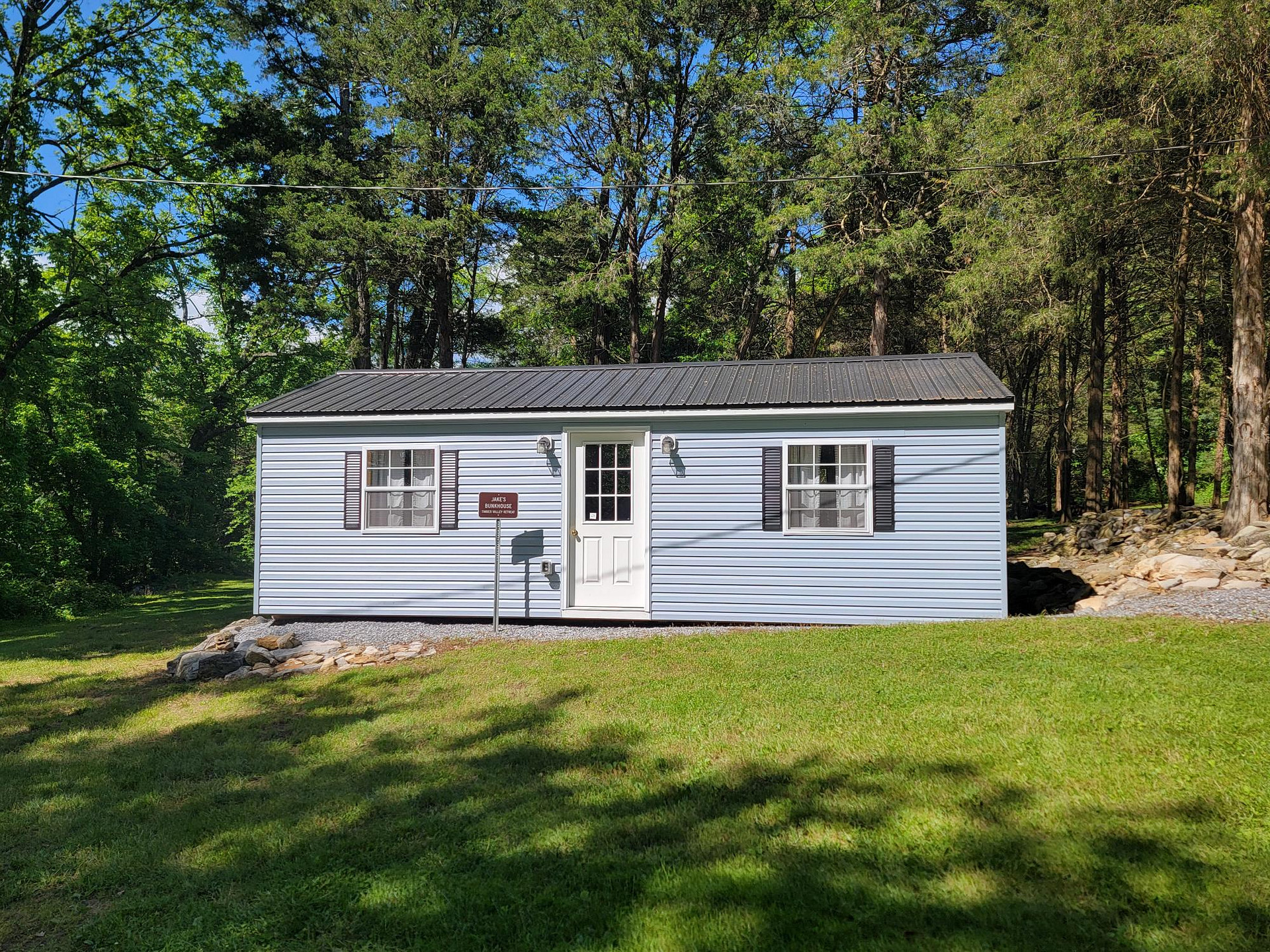 Jake's Bunkhouse at Glamping Clear Spring Maryland 3-Cabin Campground, Jake's Bunkhouse has 4 queen beds, couch, heat and AC and a chair.