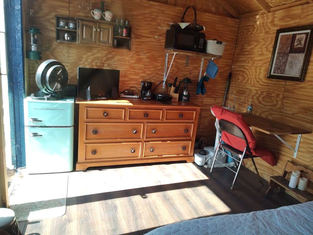 This little kitchette has everything you need for your weekend getaway.  A cold refrig/freezer, coffee maker, coffee, tea and mugs.  Microwave, heat plate, silverware, plates, cups, pots and pans inside the cabinet.  Sink to the right and a desk.