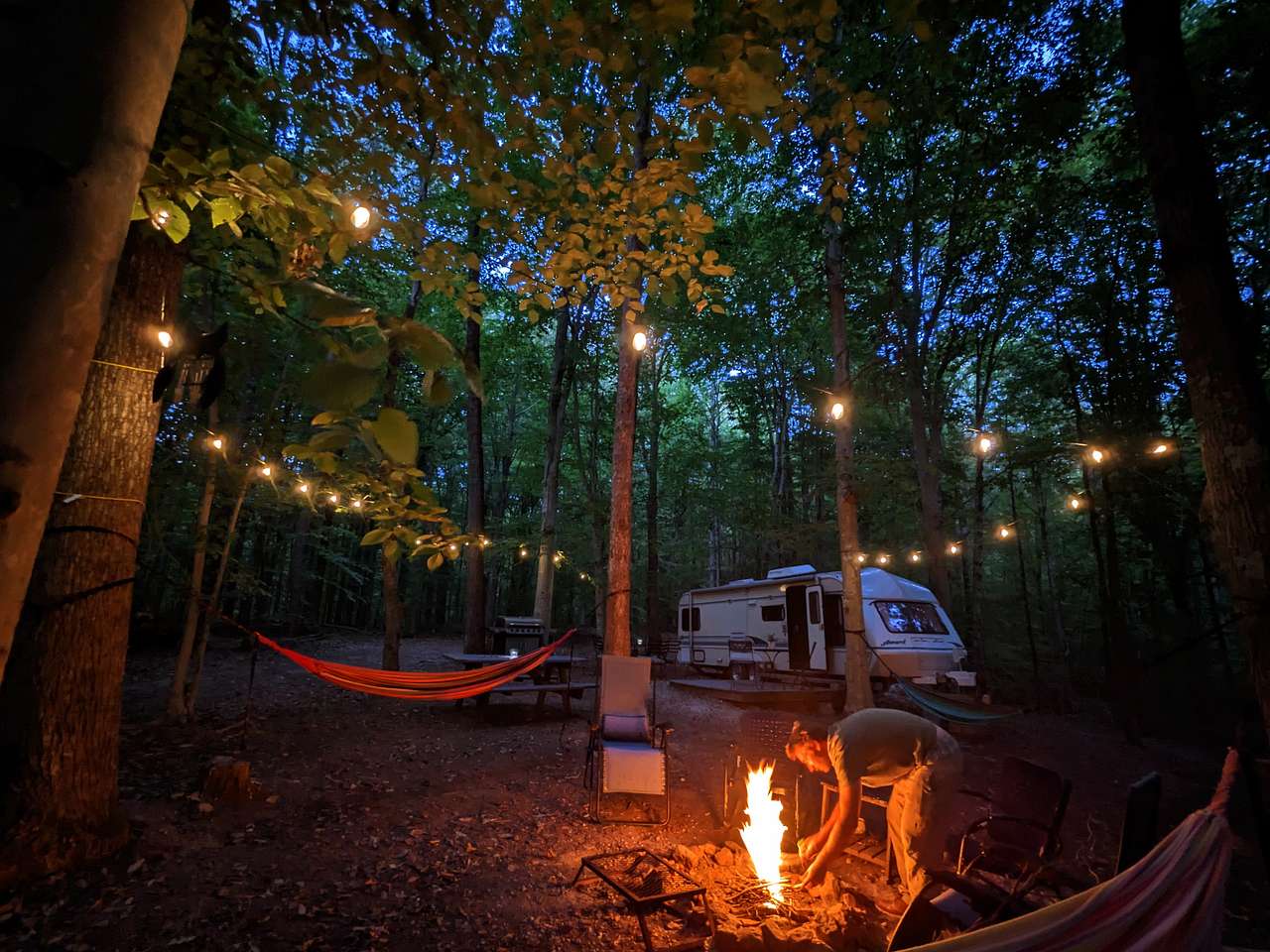 String lights are over the firepit, picnic table, and grill area. Grill grate also available. Firewood (purchase on the honor system) is available steps away from the firepit.