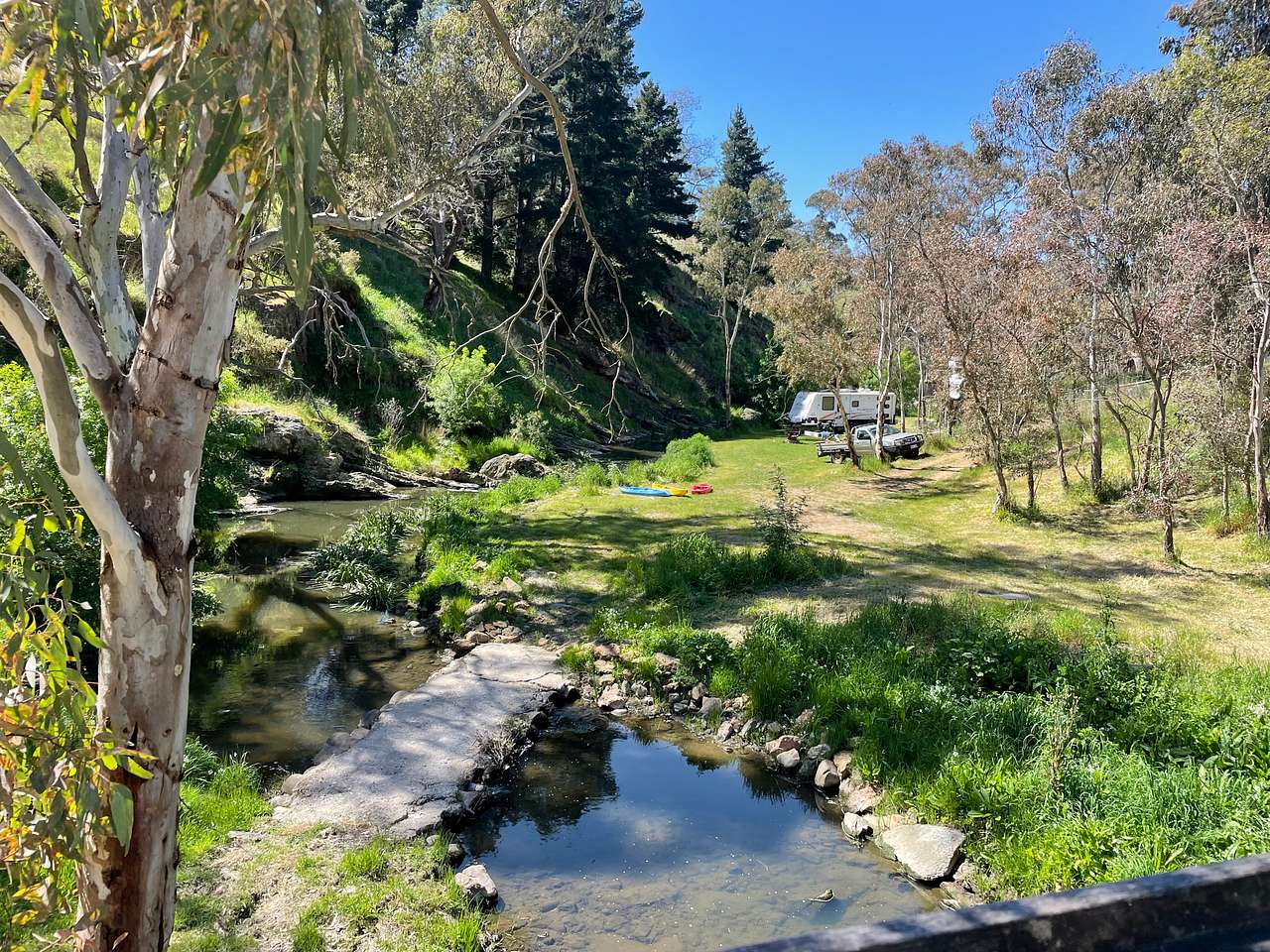 Niagra falls (which is actually like a 20cm drop in reality) is just before the kayaks in the distance and the site is to the right in the clearing in front of the trees.  Access would be coming down the track to the left of the ute,  swinging right and then reversing in.