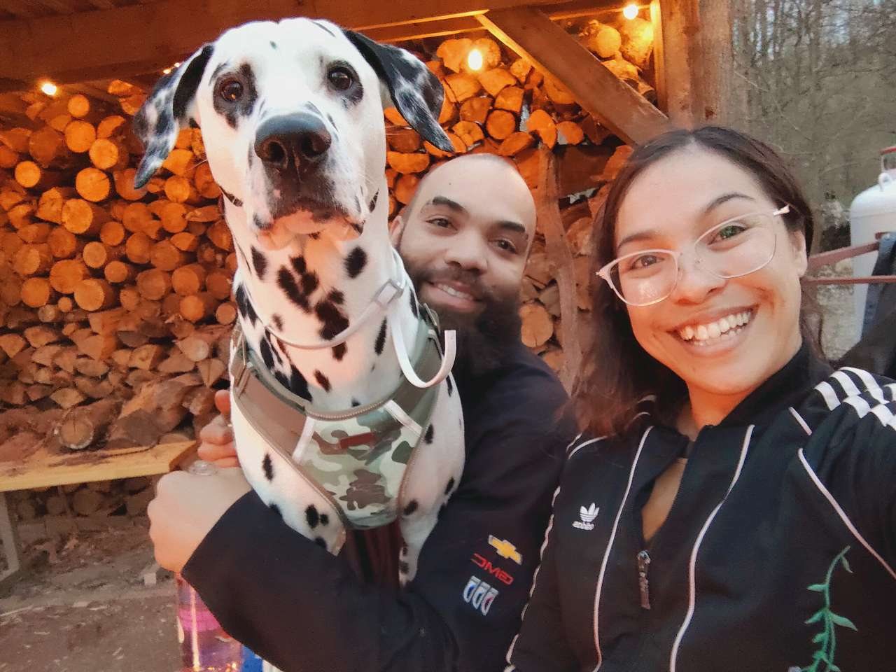 Small family of 3 sitting by campfire before sunset 