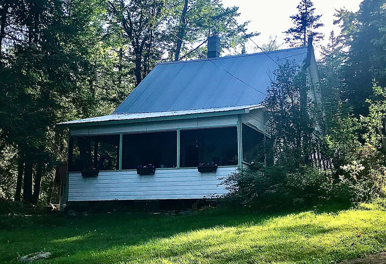The cottage has a huge screen porch that overlooks the lake. Porch furnishings include a large table with seating (for meals, playing board games and cards), a vintage chaise lounge drops down as a cot if you want to sleep within open air, hammock, and rustic armchairs. 