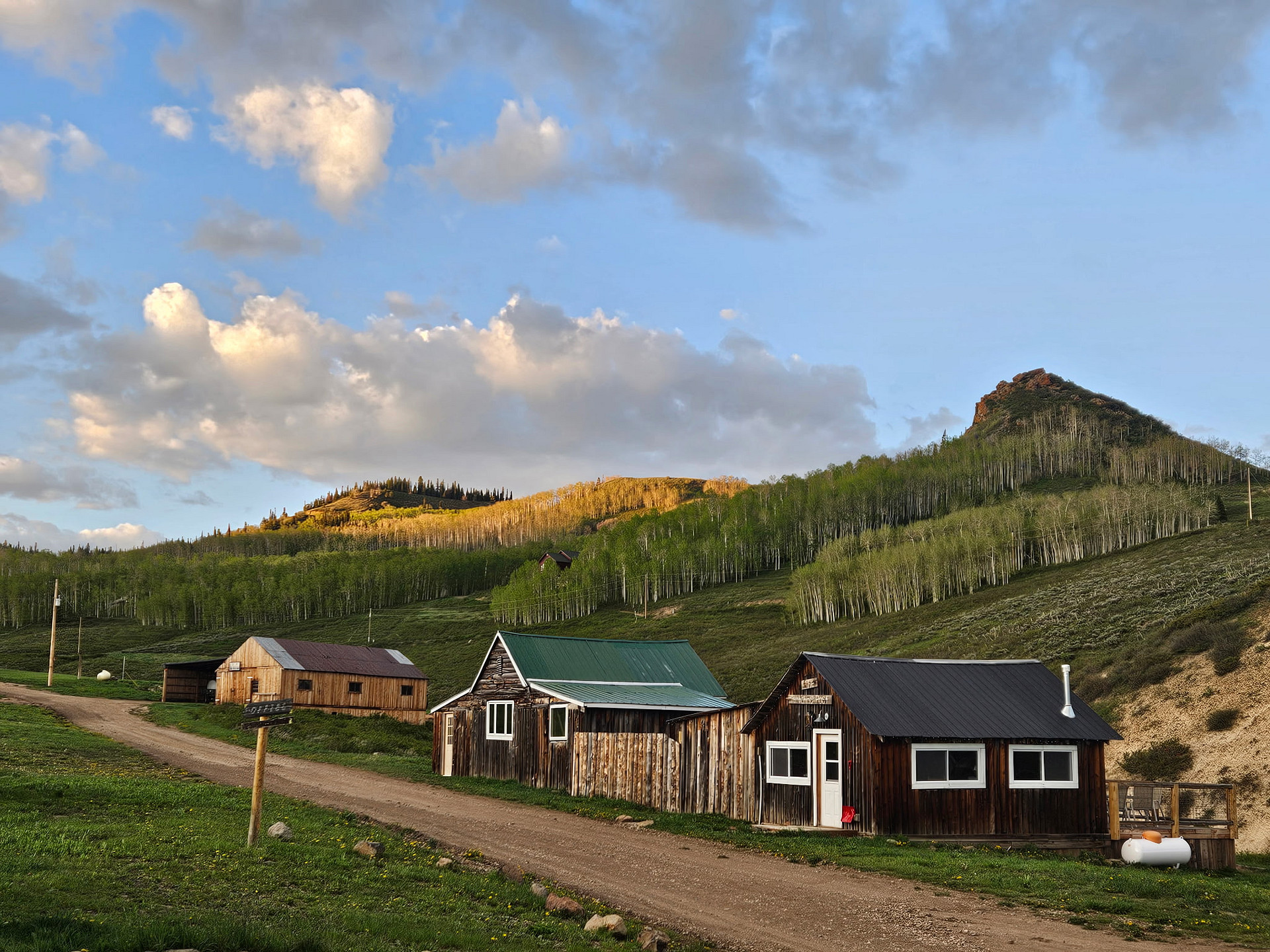 Golden hour always puts on a show at Basecamp. Here you can see the shared game room, the Hitchin' Post and our newest cabin, Valleyview.