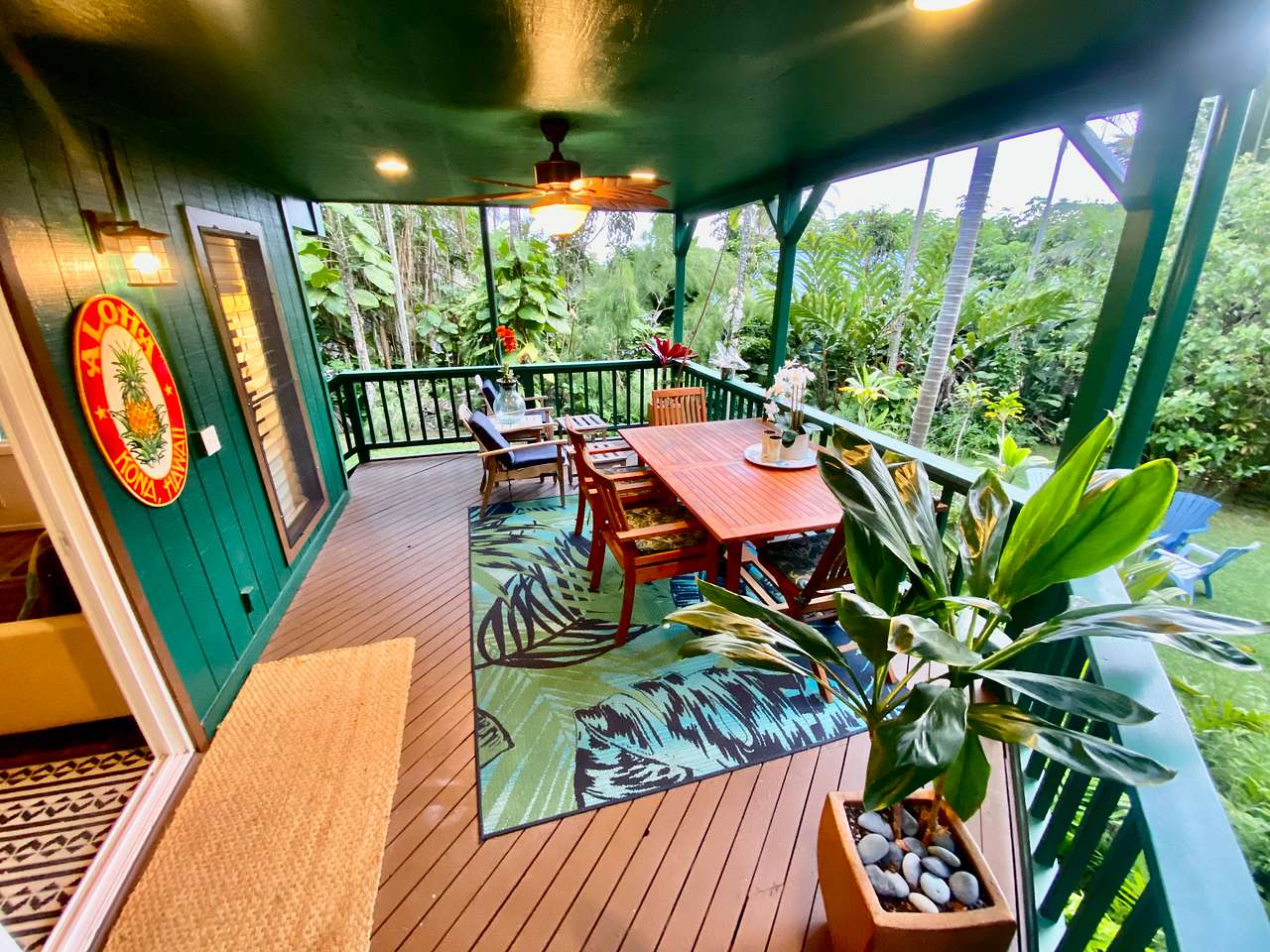 Outdoor dining lanai, spacious Tropical, surrounded by nature, seating for four, as well as two comfortable reclining chairs and foot stools for reading.