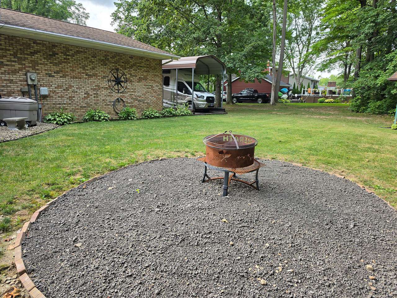 Backyard fire pit that borders the woods looking back toward the RV Port and Campsite.