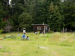 The cabin in spring. Bench with garden view right in front of it.